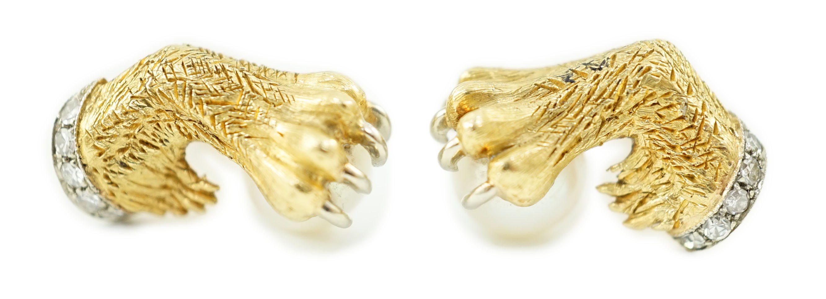 A mid 20th century pair of engraved and textured gold and platinum, diamond chip and cultured pearl cufflinks, each modelled as a lion's paw